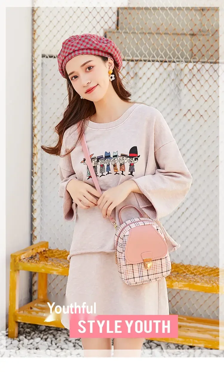 Model carrying the pink plaid backpack by its shoulder strap.