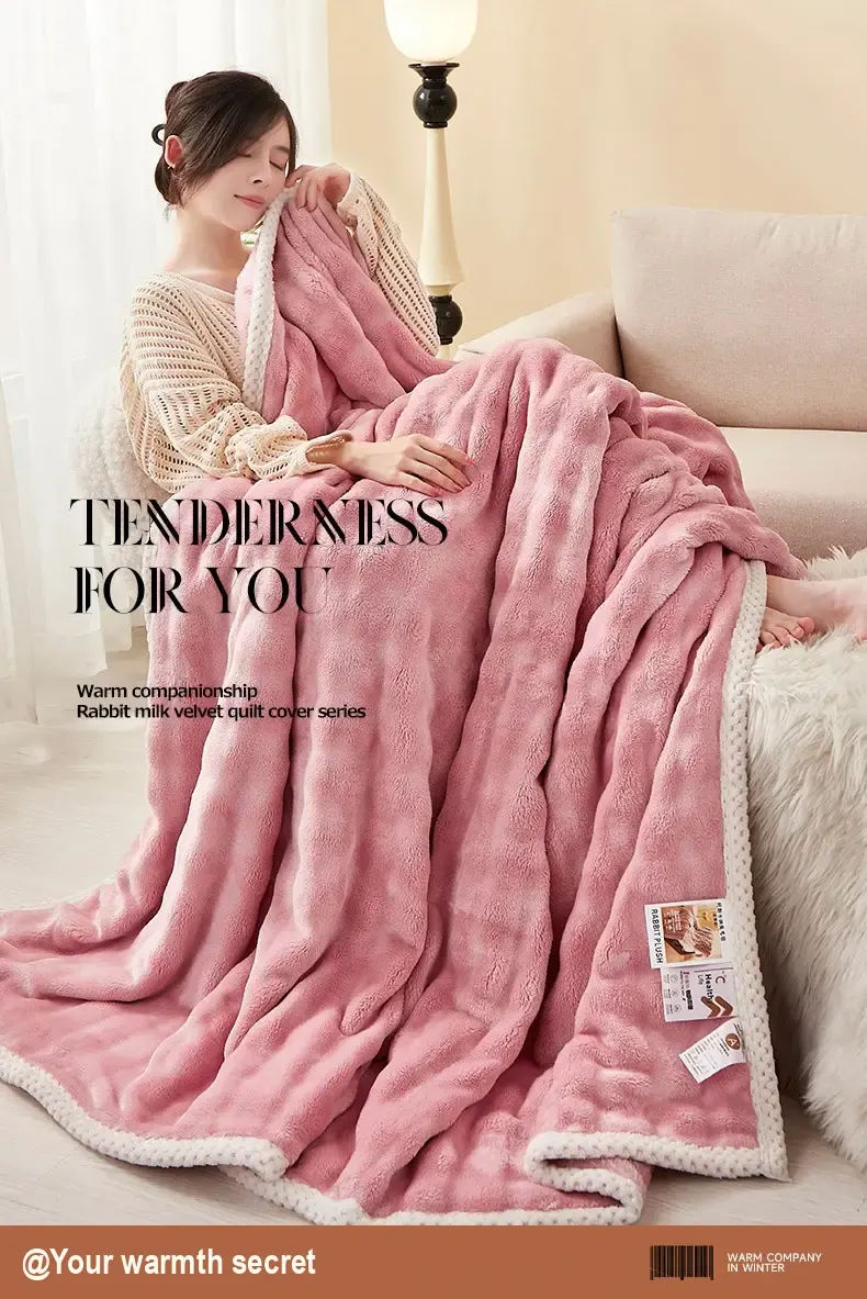 A person seated while holding a pink blanket with pale edging.