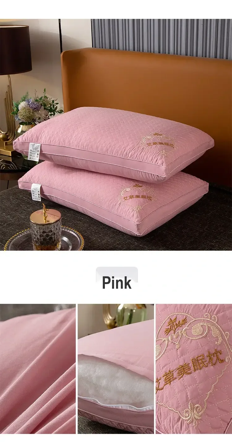 Two pink embroidered pillows displayed on a bed with a color label.