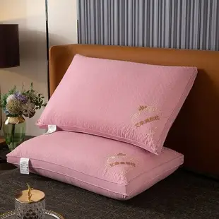 Pink embroidered quilted pillows displayed on a bed.