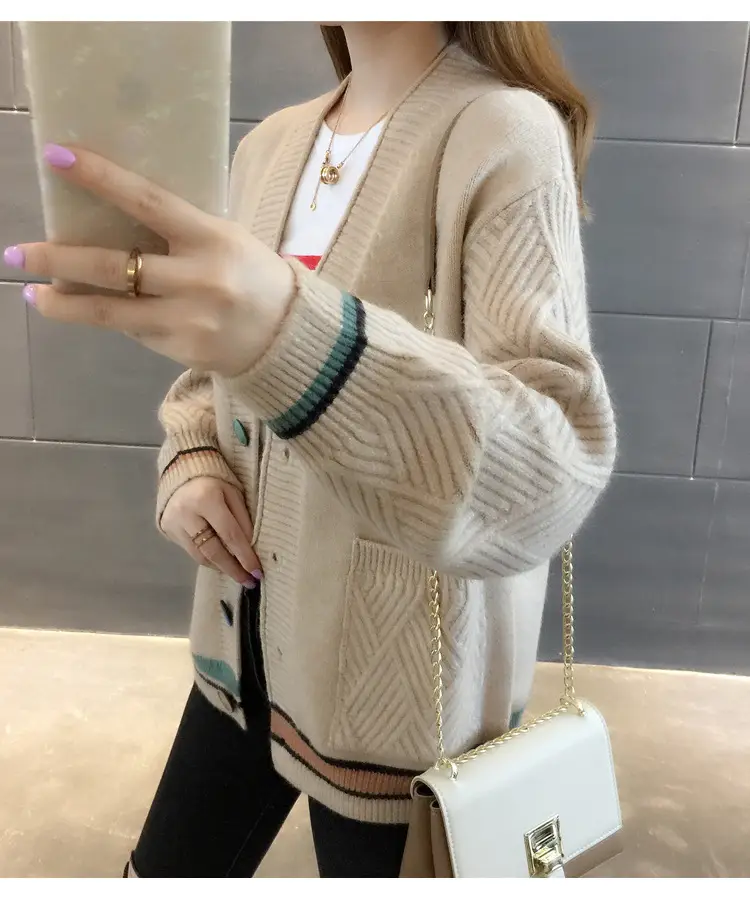 Side view of the beige cardigan with textured sleeve and contrast-striped cuff.