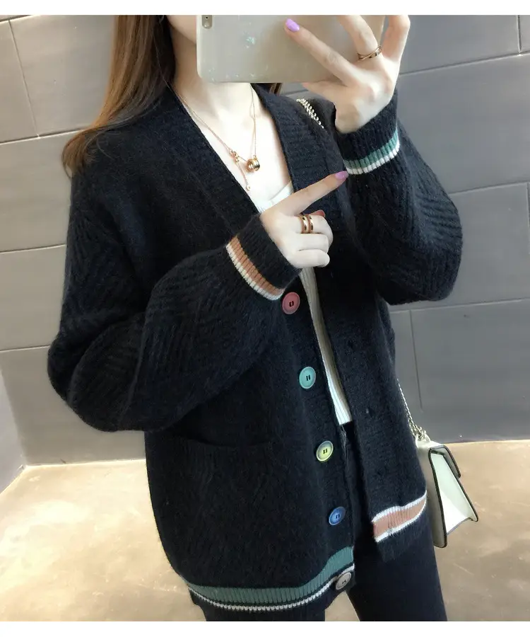 Angled view of the black cardigan showing textured sleeves and front pockets.