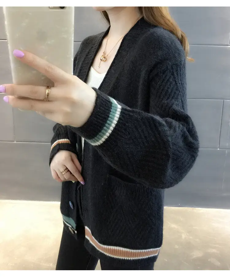 Side view of black cardigan showing textured sleeve and striped cuff and hem.
