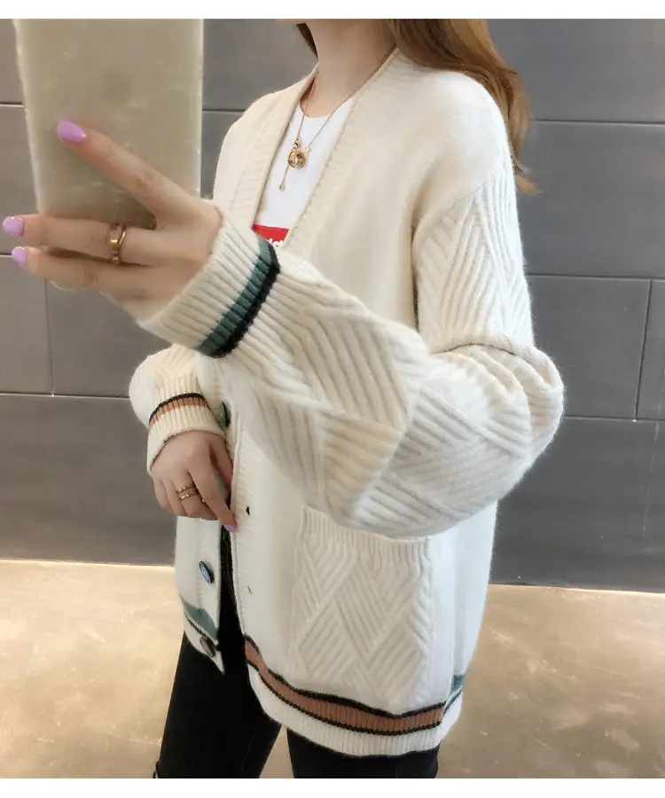 Side view of the white cardigan showing its textured sleeve and front pocket.