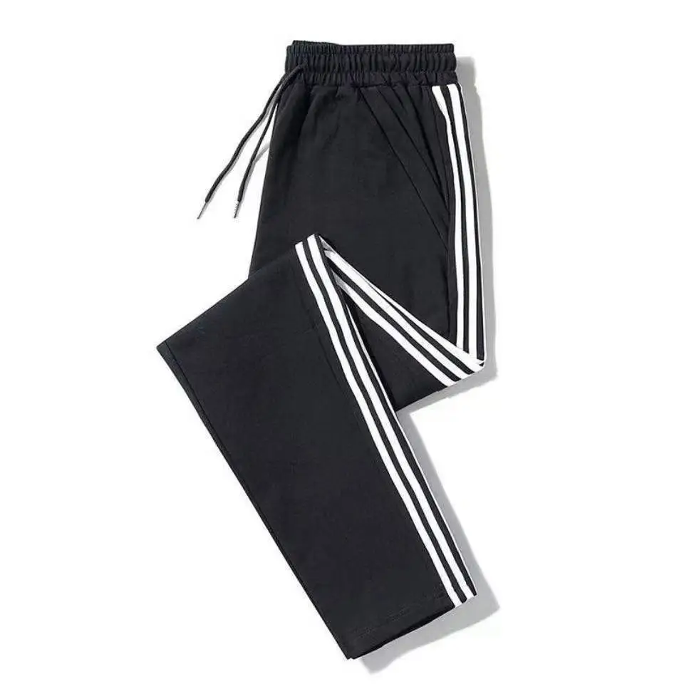 Men's Black Striped Track Pants with White Sneakers — feature 1