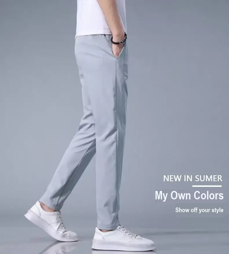 Side view of light gray pants worn with a white shirt and sneakers.