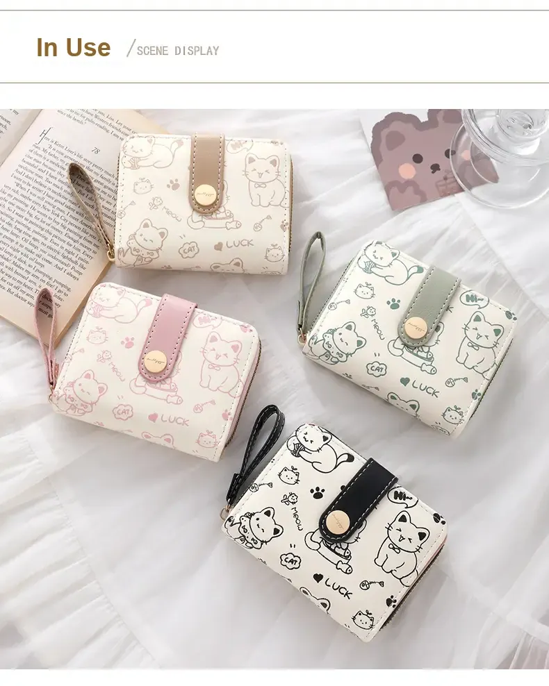 Four cream cat-print wallets shown in milk tea, pink, green and black trim options.