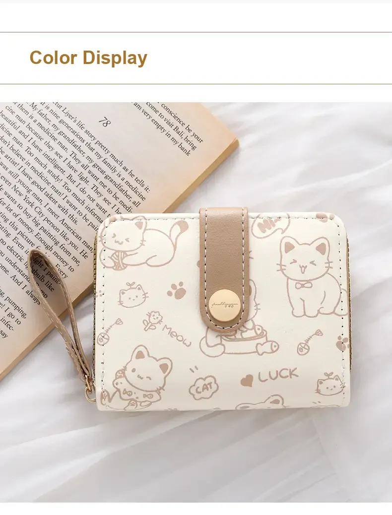 Cream cat-print wallet with beige trim and wrist strap.