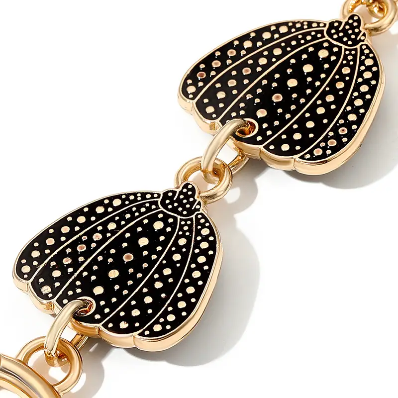 Heart-Shaped Gold Earrings with Black Polka Dot Design - Image 6